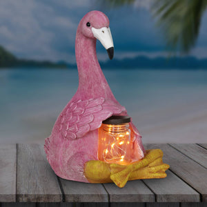 Solar Sitting Flamingo Garden Statue Holding a Glass Jar with Six LED Firefly String Lights | Shop Garden Decor by Exhart
