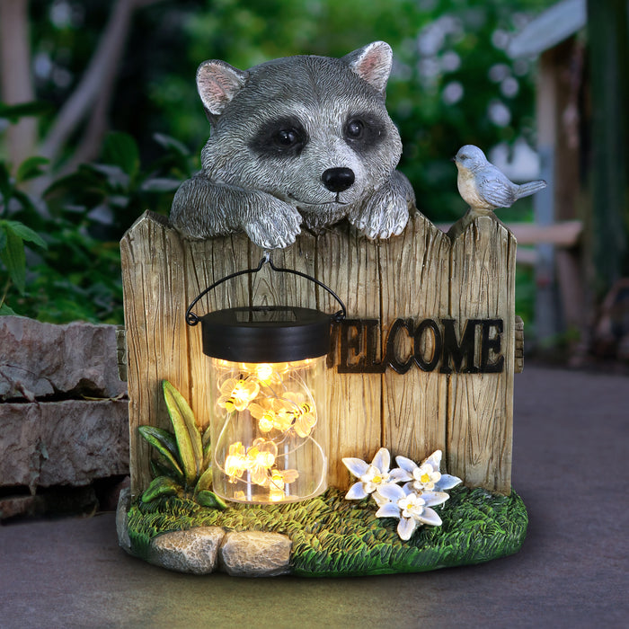 Solar Hand Painted Raccoon Garden Statue with a Lantern Jar of LED Bumblebees by a Welcome Fence, 9 by 10.5 Inches