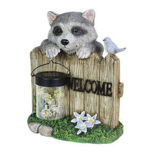 Solar Hand Painted Raccoon Garden Statue with a Lantern Jar of LED Bumblebees by a Welcome Fence, 9 by 10.5 Inches | Exhart